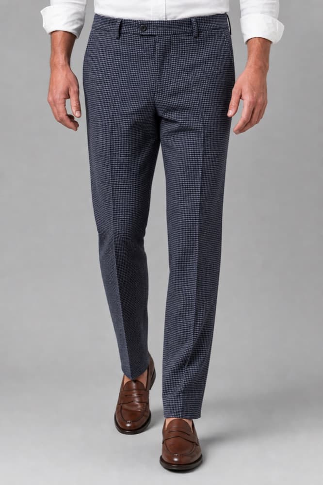 Tailored trousers photographed against a deep blue studio wall