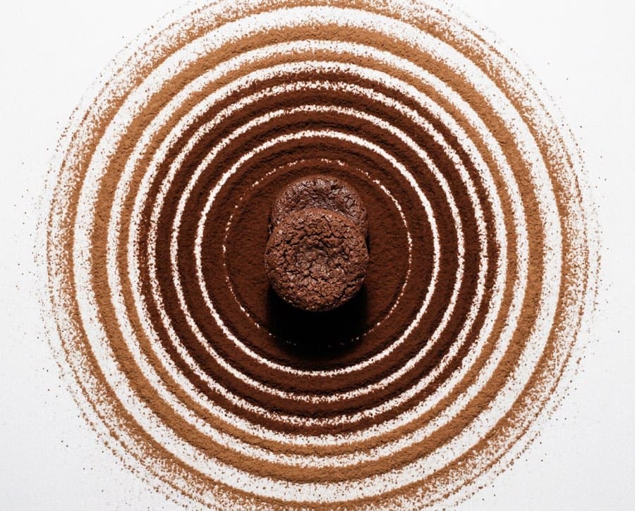 A brownie centred in concentric rings of sifted cocoa